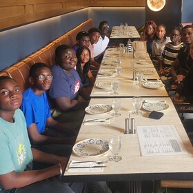 élèves et adultes assis à une longue table de restaurant